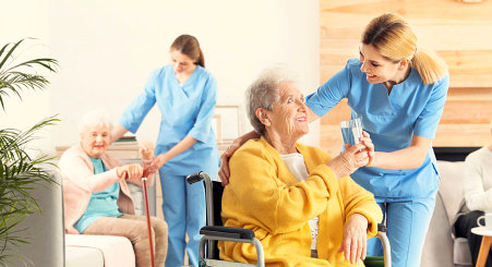 caregiver giving a glass of water to a senior woman