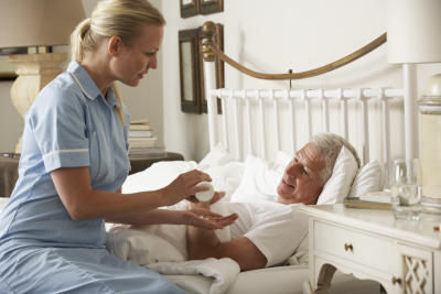 a caregiver giving the medicine to a sick senior man
