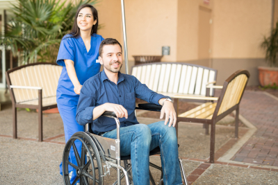 male patient being pushing on a wheelchair by a nurse